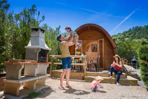 Camping Prades Park Camper-Familie vor einer Camping-Pod Mietunterkunft mit eigenem Grill und eigener Terrasse