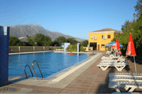 Camping Presa La Viňuela - Swimmingpool mit Liegestühlen und Sonnenschirmen