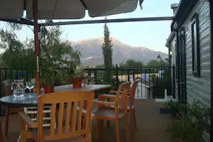 Camping Presa La Viňuela - Veranda eines Mobilheims mit Sonnenschirm und Sitzgelegenheiten