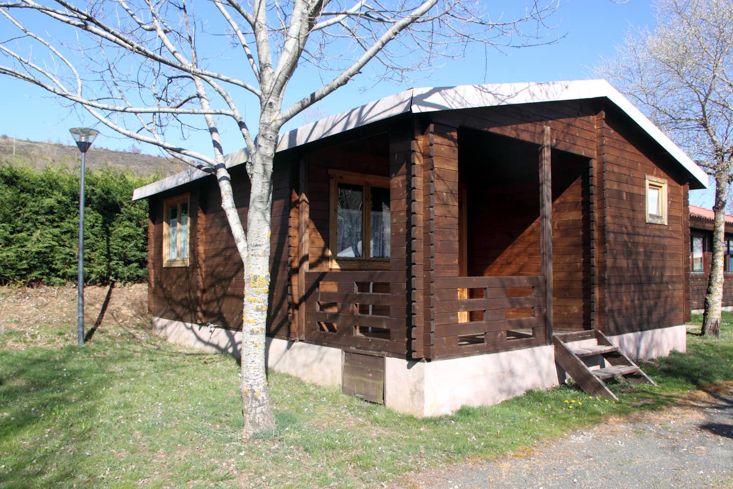 Camping Puerta de la Demanda - Holz Bungalow mit überdachter Veranda auf dem Campingplatz