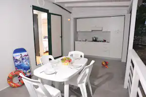 Camping Punta Lunga - überdachte Terrasse eines Mobilheims mit Kochnische und Esstisch