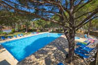 Yelloh! Village Punta Milà  -  Pool vom Campingplatz mit Liegestühlen in der Sonne