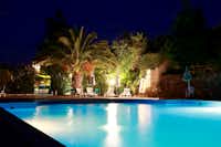 Camping Quinta das Cegonhas - Der Swimmingpool am Abend mit Liegestühlen unter Palmen
