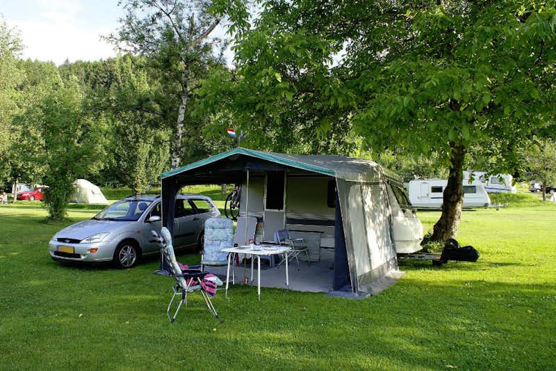 Camping Reichmann - Wohnwagen mit Vorzelt unter einem Baum auf dem Campingplatz