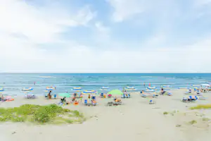 Camping Reno - Blick auf den Badestrand mit Liegestühlen und Sonnenschirmen