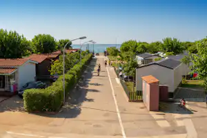 Camping Resort Els Pins - Gehweg auf dem Campingplatz entlang Mobilheime zum Mittelmeer