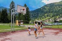 Camping & Resort Fiemme Village - Kinder spielen Basketball auf dem Sportplatz des Campingplatzes mit Blick auf Berge