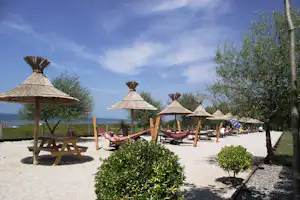 Camping Resort Lake Shkodra - Badestrand mit Liegestühlen und Sonnenschirmen beim Campingplatz