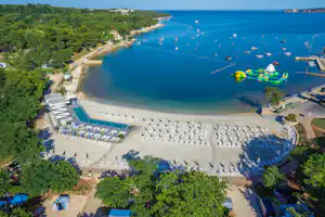 Lanterna Premium Camping Resort - Campingplatz mit Sonnenschirmen und Liegestühlen am Strand der Adria