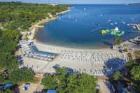 Lanterna Premium Camping Resort  -  Campingplatz mit Sonnenschirmen und Liegestühlen am Strand der Adria