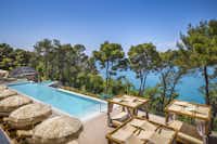 Lanterna Premium Camping Resort - Blick auf den Pool und die Relax-Liegen sowie das Meer