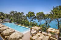 Lanterna Premium Camping Resort - Blick auf den Pool und die Relax-Liegen sowie das Meer