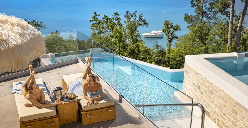 Lanterna Premium Camping Resort - Gäste beim Entspannen am Pool mit Meerblick