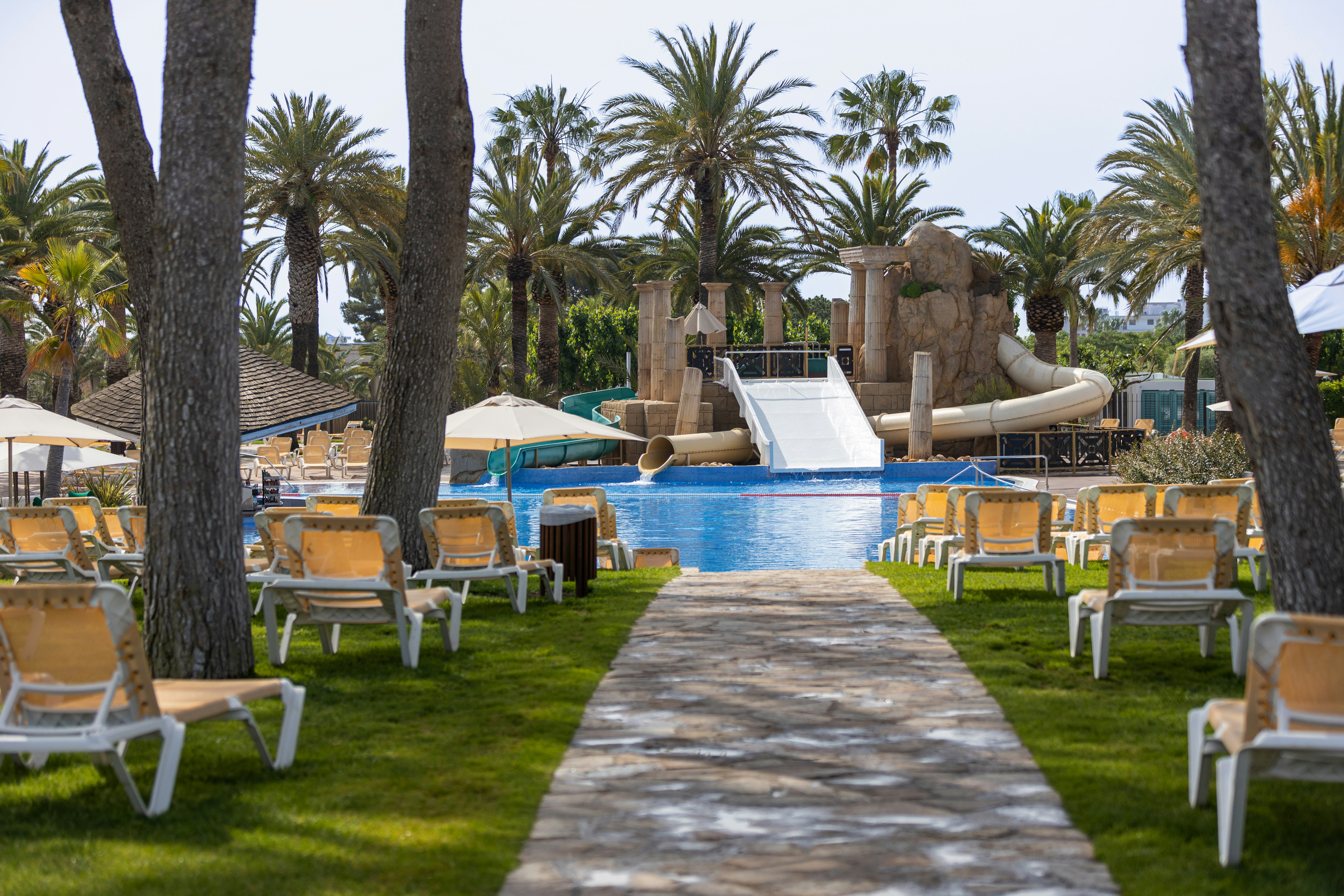 Camping & Resort Sangulí Salou Blick auf einen Pool mit Rutsche sowie die Liegewiese mit Liegestühlen