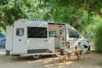 Camping & Resort Sangulí Salou Familie mit Campingvan auf einem Standplatz im Halbschatten unter Bäumen