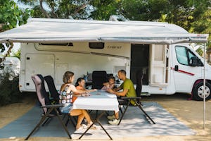 Sangulí Camping & Resort - Familie sitzt vor einem Wohnmobil