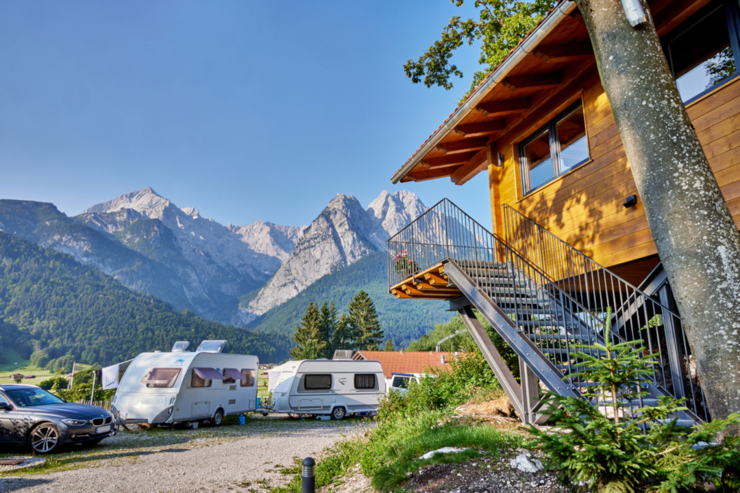 Camping Resort Zugspitze - Baumhaus und Standplätze auf dem Campingplatz mit Blick auf die Berge