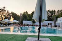 Camping Rialto - Gäste entspannen am Pool bei Sonnenuntergang