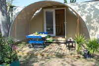 Camping Riccardo - Glamping Zelt mit überdachter Holzterrasse, auf der Sitzgelegenheiten stehen