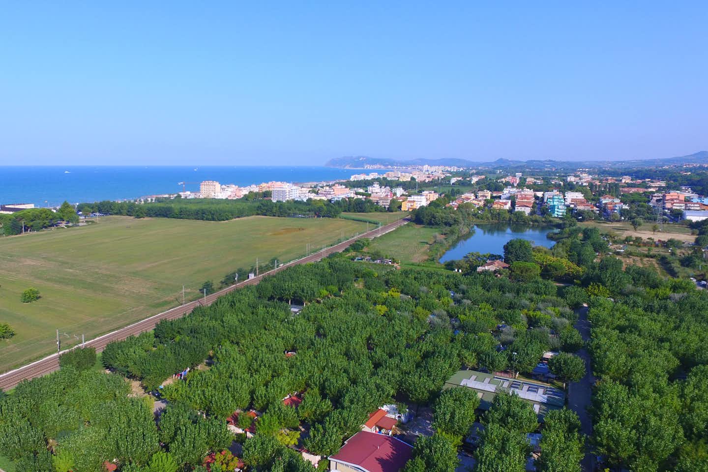 Camping Riccione - Luftaufnahme auf den Campingplatz im Vordergrund, mit nahen Ortschaften und dem Mittelmeer im Hintergrund