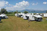 Camping Rino - Wohnmobile auf der Stellwiese mit dem See im Hintergrund