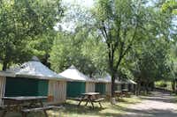 Camping Rio Vero - Mobilheime mit Picknicktischen vom Campingplatz zwischen Bäumen