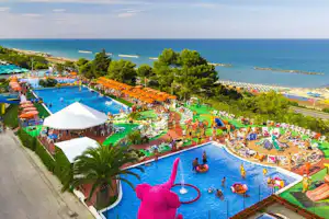 Camping Riva Verde - Blick auf die Poolanlage des Campingplatzes mit Liegestühlen und Sonnenschirmen am Rand
