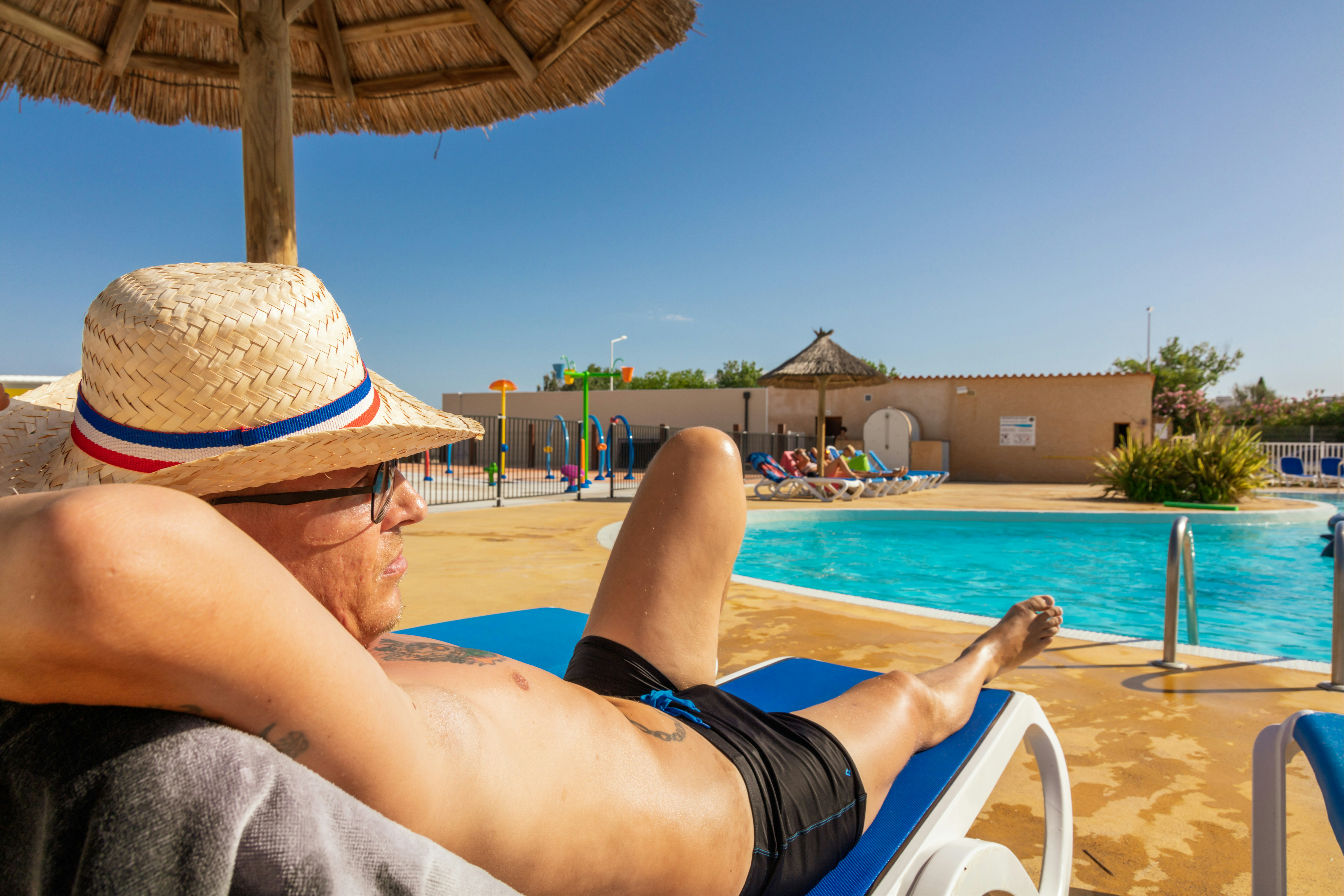 Camping Rives des Corbières - Camper entspannt auf einem Liegestuhl am Pool