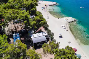 Camping Rožac - Standplätze umgeben von Baumen und kleinen Hecken mit direkten Zugang zum Meer