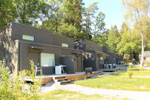 Camping Rösjöbaden - Mobilheime vom Campingplatz mit Veranda, Esstischen und Grill