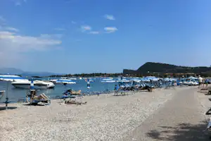Camping Romantica - Strand vom Campingplatz am Gardasee mit Sonnenschirmen und Liegestühlen