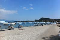 Camping Romantica  -  Strand vom Campingplatz am Gardasee mit Sonnenschirmen und Liegestühlen
