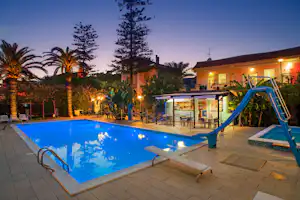 Camping Rosa - Pool und Poolbar vom Campingplatz zwischen Palmen am Abend