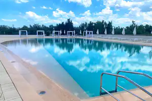 Camping Rosapineta - Pool mit Liegestühlen und Sonnenschirmen