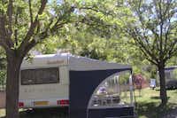 Camping Rose de Provence - Wohnwagen mit Vorzelt zwischen Bäumen