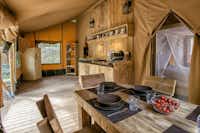 Camping Rosselba le Palme - Innenraum eines Safari Glampingzeltes mit Kochecke und Esstisch