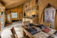 Camping Rosselba le Palme - Innenraum eines Safari Glampingzeltes mit Kochecke und Esstisch