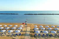 Camping Sabbia D'oro - Blick auf den Badestrand mit Liegestühlen und Sonnenschirmen