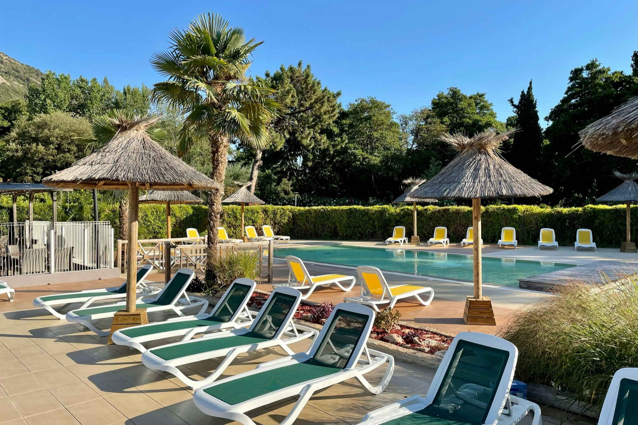 Camping Sagone - Freibad mit Liegestühlen und Sonnenschirmen