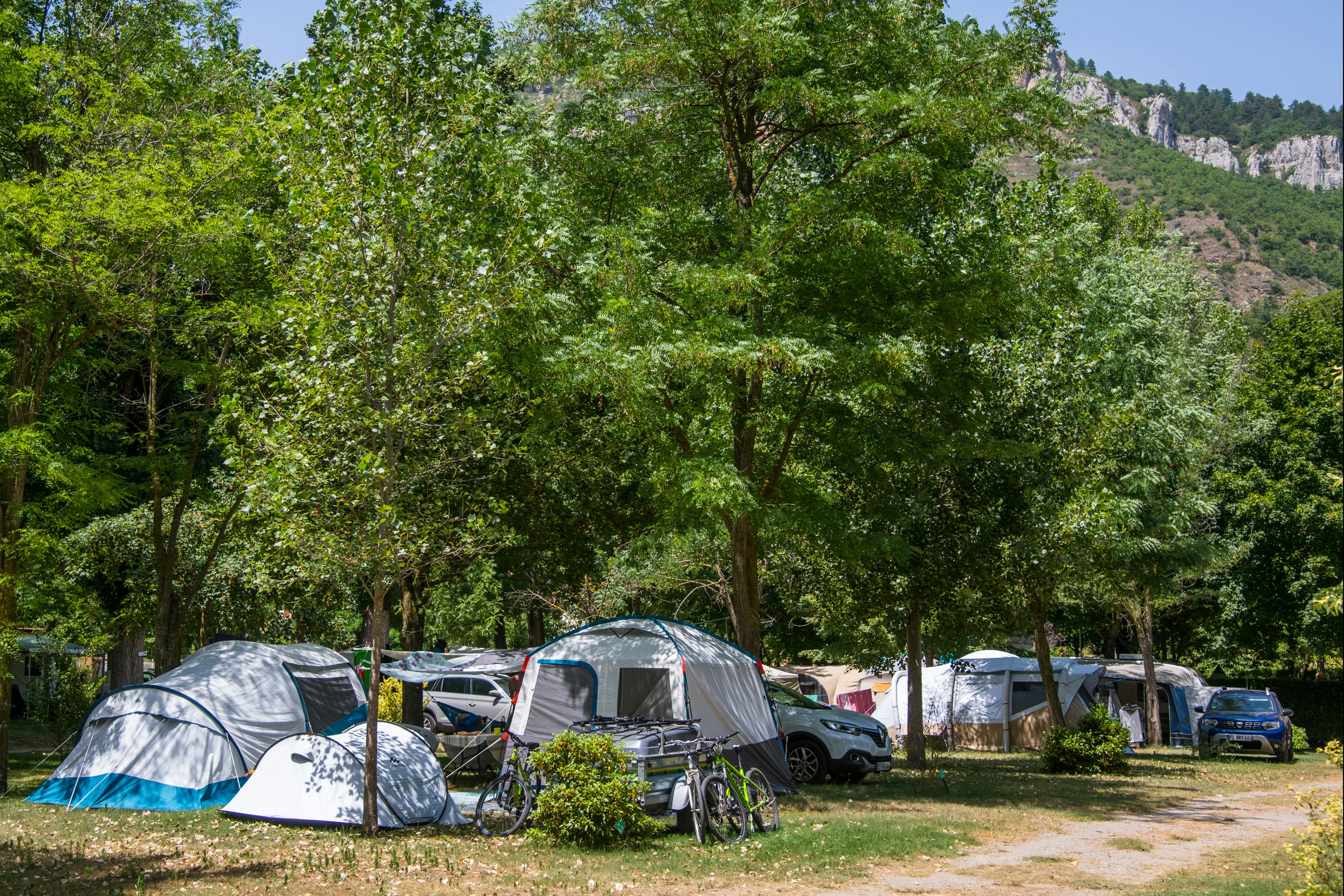 Camping Saint Lambert - Standplätze zwischen Bäumen auf dem Campingplatz