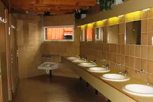 Camping Salzmann Rohrspitz - Sanitärgebäude vom Campingplatz mit Waschbecken, Spiegeln und Toilettenkabinen