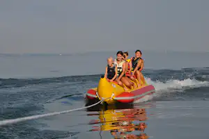 Camping Salzmann Rohrspitz - Bananenboot fahrende Camper auf dem See am Campingplatz