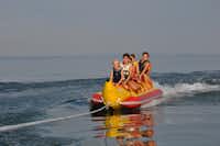 Camping Salzmann Rohrspitz  - Bananenboot fahrende Camper auf dem See am Campingplatz
