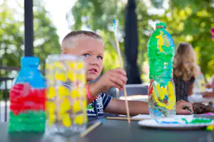 Camping San Cristoforo - Kind mit Pinsel in der Hand beim Malen im Kids Club des Campingplatzes