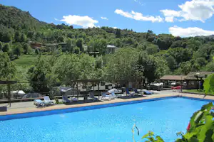 Camping San Pelayo - Pool vom Campingplatz umgeben von grünen Hügeln