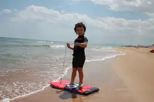 Camping San Vicente - Kind beim Surfen am Strand vom Campingplatz