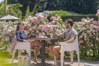 Camping Sandaya la Côte de Nacre - Paar trinkt draußen vor den Blumen