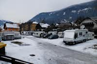 Camping Sankt Michael - Wohnwagenstellplätz im Schnee auf dem Campingplatz mit Blick auf die Berge