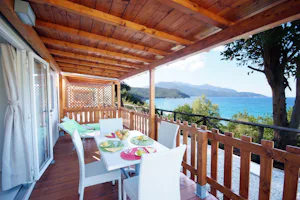 Camping Scaglieri - gedeckter Tisch und Liegestühle auf der Terrasse von einem Mobilheim auf dem Campingplatz