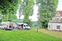 Camping Schloss Podewils - Campervans auf einer Wiese vor dem See